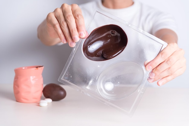 a man is holding a box with a chocolate egg inside