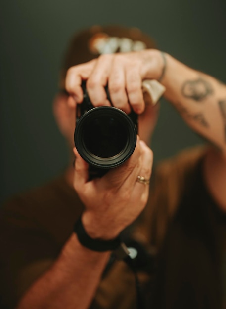 Photo a man is holding a camera with a tattoo photographer