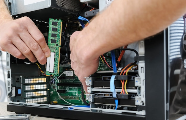 A man is holding a RAM slot to upgrade of the computer.