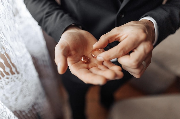 Photo a man is holding two gold rings in his hands