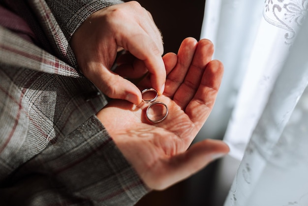 Photo a man is holding two wedding rings in his hand