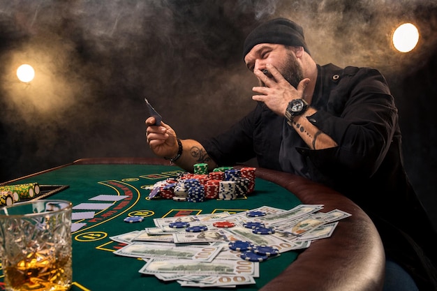 Man is playing poker. Emotional fail in game, game over for card player, man very angry with foolish choices, losing all the chips on bank.