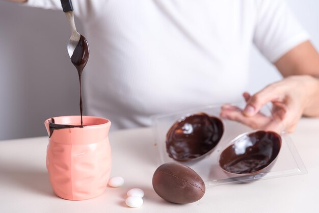 a man is pouring chocolate into a cup with a spoon