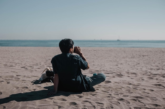 A man is sitting on the beach