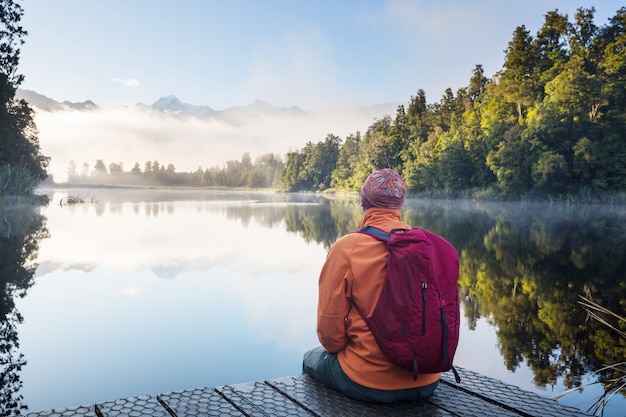 Photo a man is sitting at ease by the calm lake. relaxation vacation