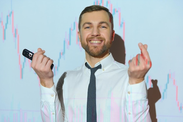 Man is standing near projector and showing graphs and business graphs