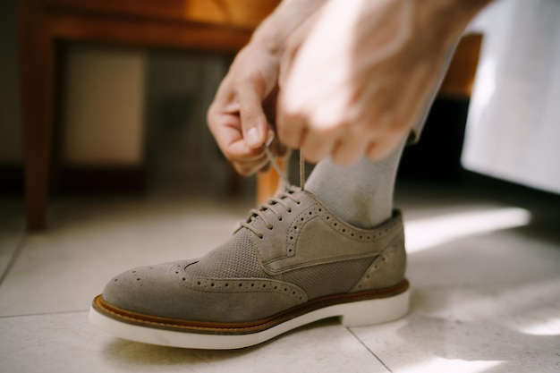 Man is tightening the laces on his shoes closeup