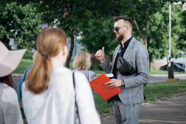 Man is a tour guide inviting a group of tourists on a tour