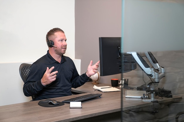 Man is working in a callcenter with headphones and computer