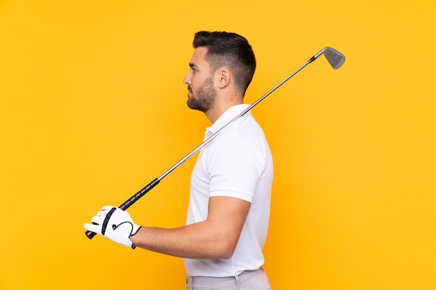 Man over isolated yellow wall playing golf