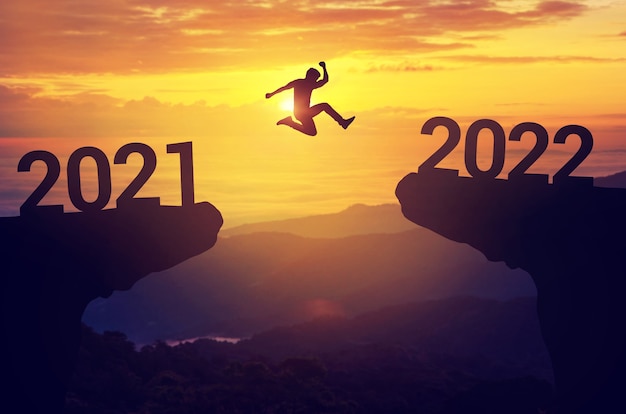 Man jump between 2021 and 2022 years with sunset background