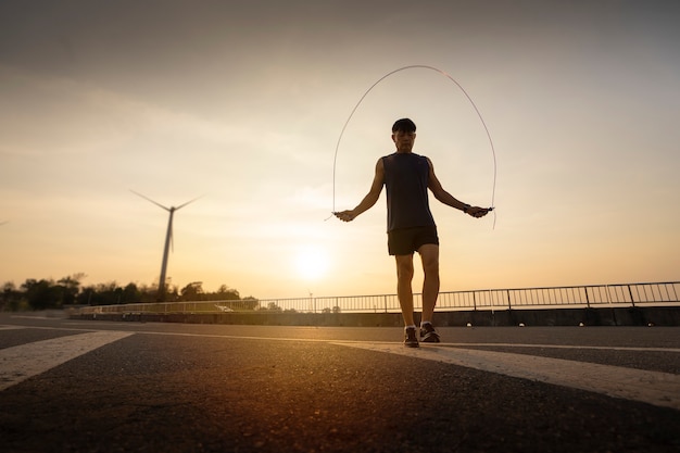 Man jumping rope in the rays of the sun. Healthy lifestyle.