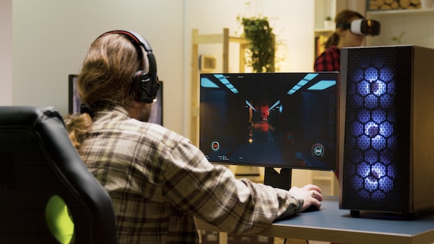 Man keeping his head on desk after losing at video games on computer. Game over for male gamer.