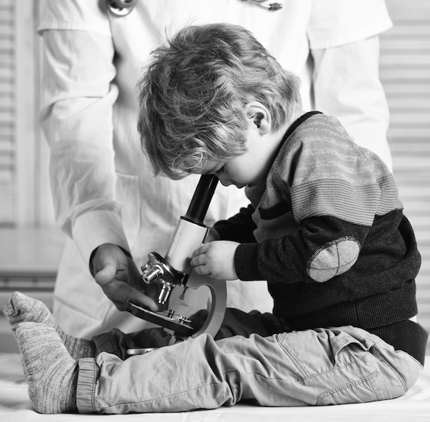 Man and kid with busy face playing doctor or scientist