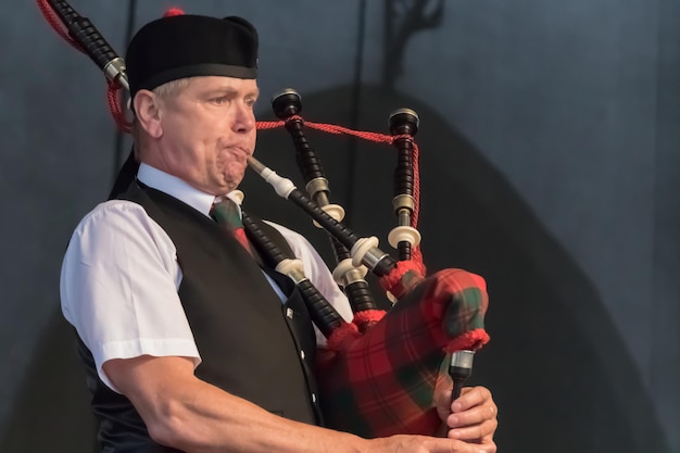 A man in a kilt playing Scottish bagpipe