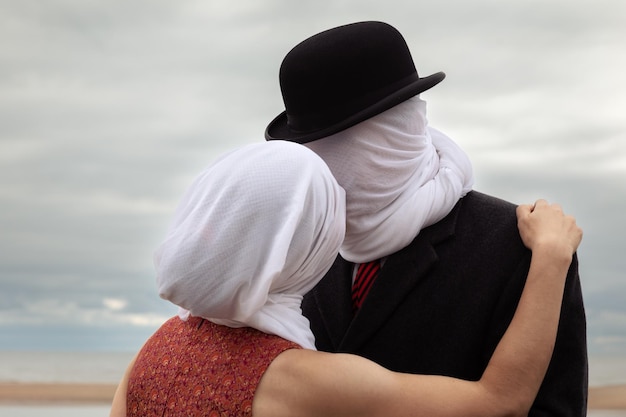 Man kissing woman with white fabrics on their heads