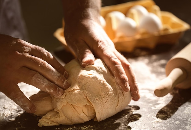 Man kneading dough in kitchen closeup