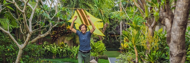 Man launch a kite in the park in Ubud, Bali Island, Indonesia BANNER, LONG FORMAT