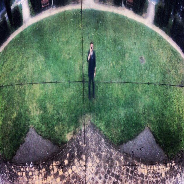 Photo man on lawn through fisheye lens