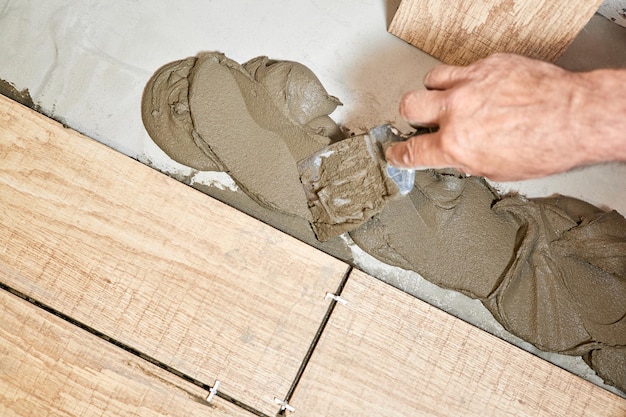 Man laying ceramic floor tiles