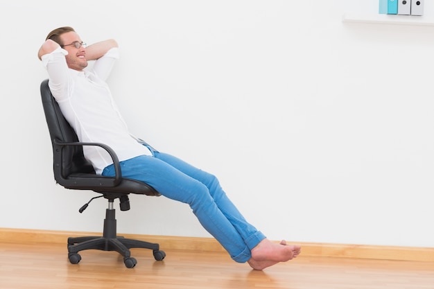 A man leaning back in swivel chair at home 