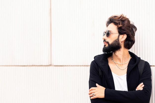 Man leaning in a white wall looking to the side