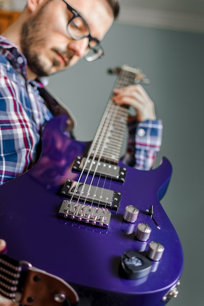 Man learn playing electric guitar at home