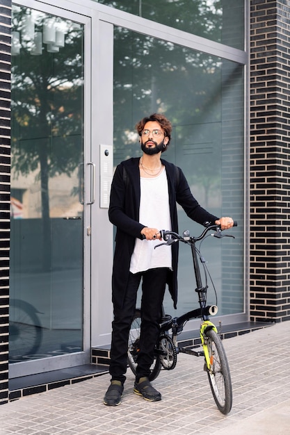 Man leaving his front door walking with his bike