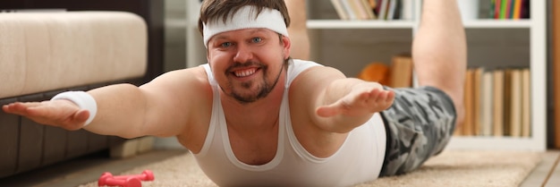 Man lies with excess weight doing exercises lying for spine at home