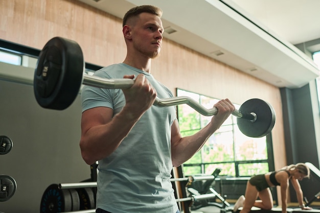 Man lifting barbell in gym