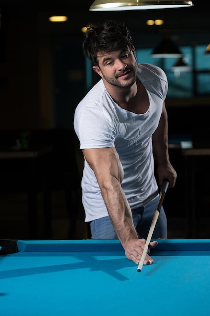 Man Lining To Hit Ball On Pool Table