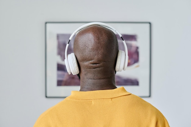 Man listening to guide in headphones at gallery