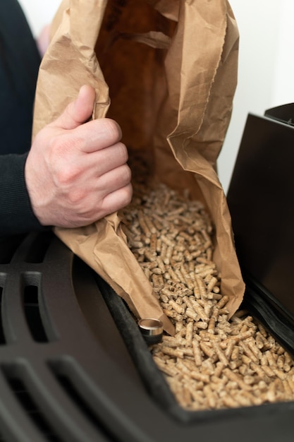 Man loading pellet stove with granule bag