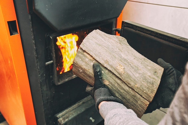 Man loads the firewood in the solid fuel boiler in the boiler room Solid fuel and heating concept