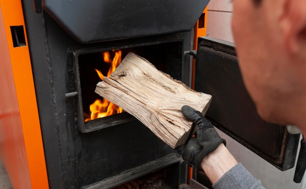 Man loads the firewood in the solid fuel boiler in the boiler room Solid fuel and heating concept