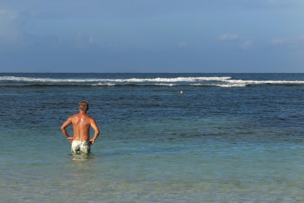 Man lonely on tropical sea under blue sky