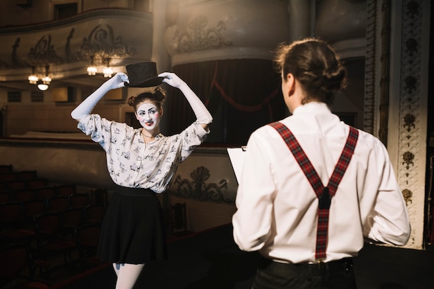 Man looking at female mime artist performing on stage