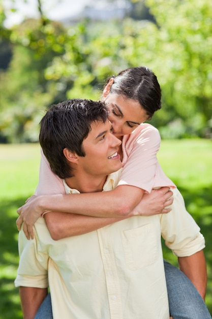 Man looking at his friend as he is carrying her on his back