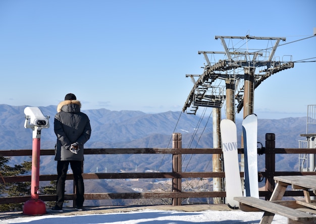 Man looking at the mountain at winter from pier