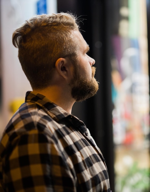 Man looking at shop window in evening street  store and shopaholic consumerism concept