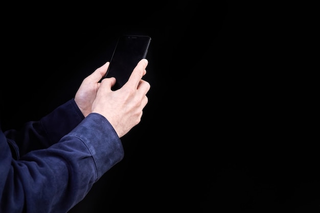 Man looking at smartphone screen on dark background