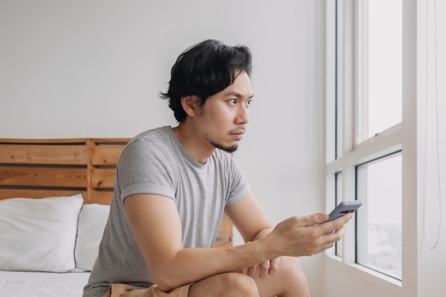 Man looking at smartphone with serious face