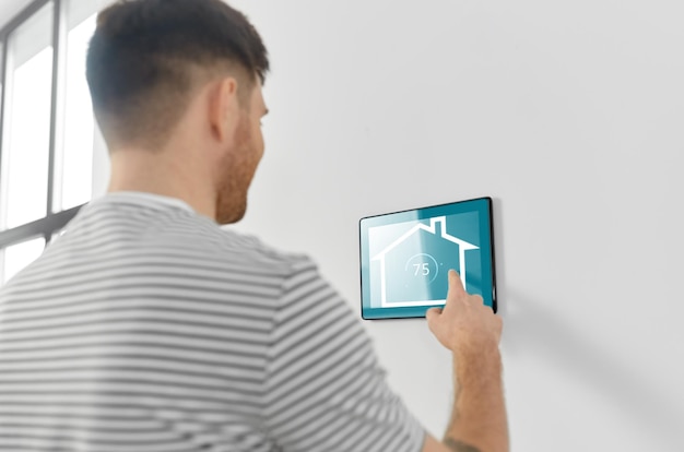 Photo man looking at tablet computer at smart home