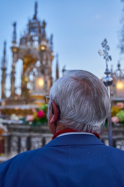 A man looks at a statue of the cross