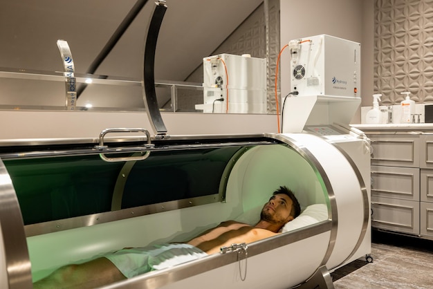 Man lying in oxygen capsule in medical office