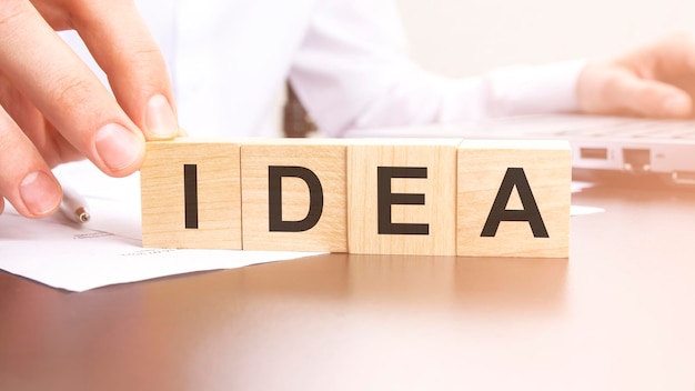 Man made text IDEA with wood blocks on the background of the office table selective focus business concept