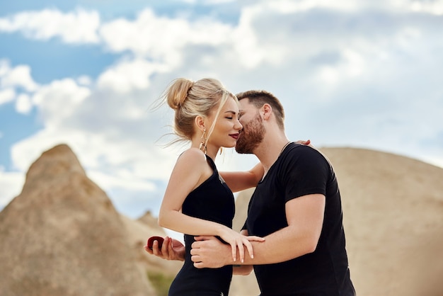 Photo man makes a marriage proposal to his girlfriend. engagement of a couple in love in nature. the guy wears a wedding ring on a woman's finger. happy emotions on your face. turkey, cappadocia, 9 may 2018