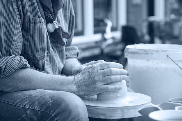 Photo a man makes a pitcher of clay