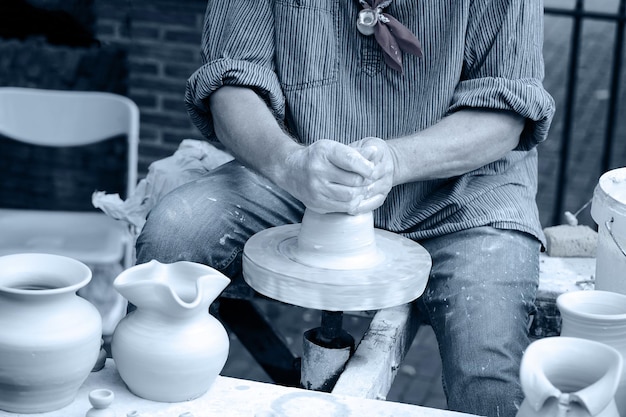 A man makes a pitcher of clay