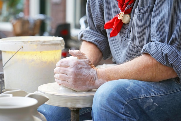 A man makes a pitcher of clay